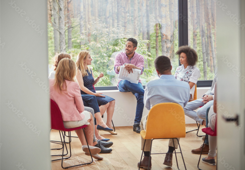 Menschen unterhalten sich im Stuhlkreis